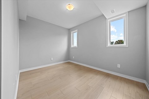 A room with a window and a wooden floor.