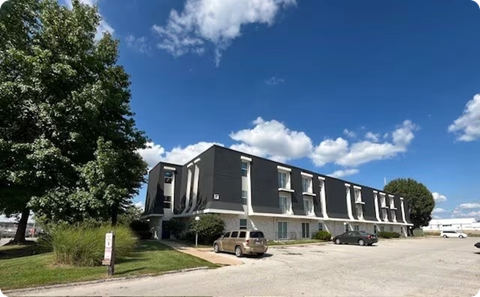 A modern building with a parking lot in front.