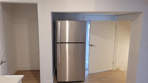 A stainless steel refrigerator in a white room.