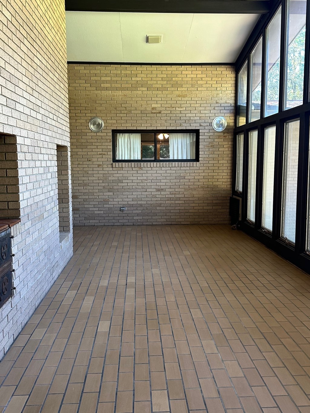 A long hallway with brick walls and tile floors.