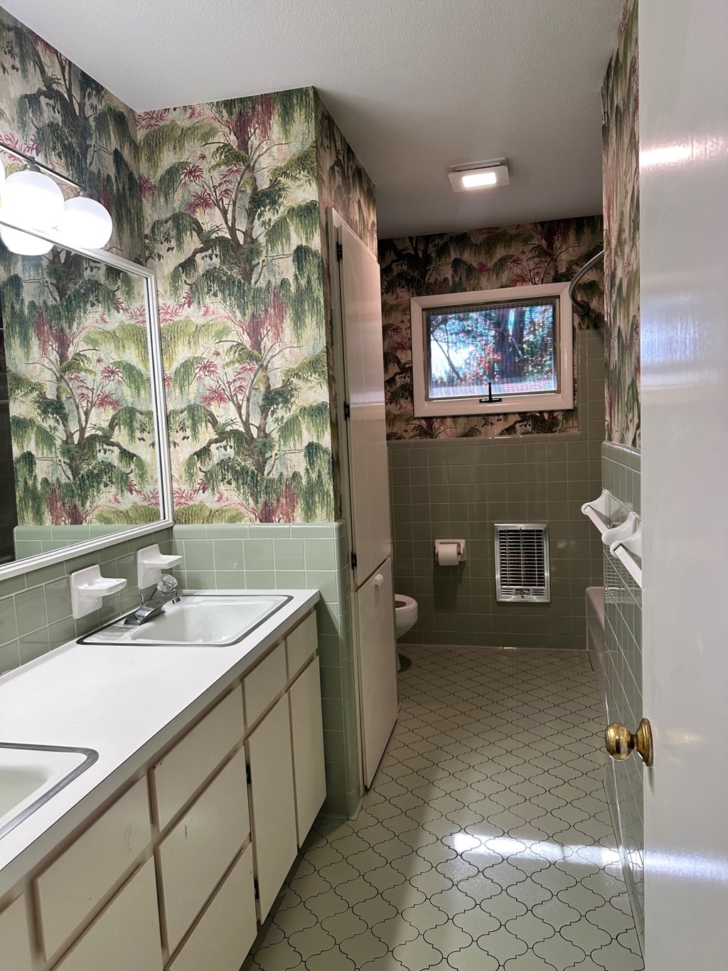 A bathroom with a sink, mirror, and tiled floor.