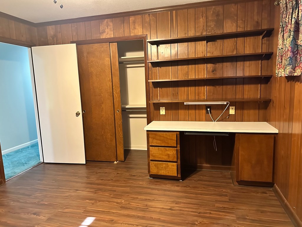 A room with a desk and drawers in it.