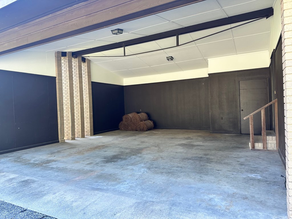 A room with a concrete floor and a dark wall.