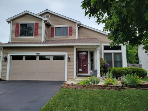 A house with a brown garage door and a red door.
