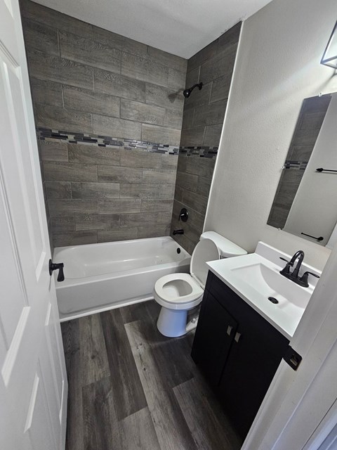 A bathroom with a toilet, sink, and bathtub.