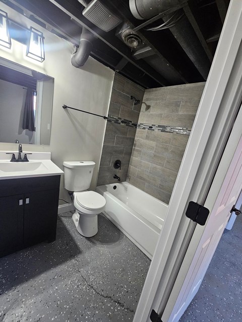 A bathroom with a toilet, sink, and shower.