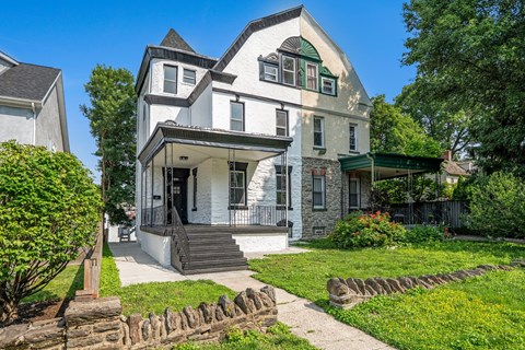A white house with a green roof and a black door.