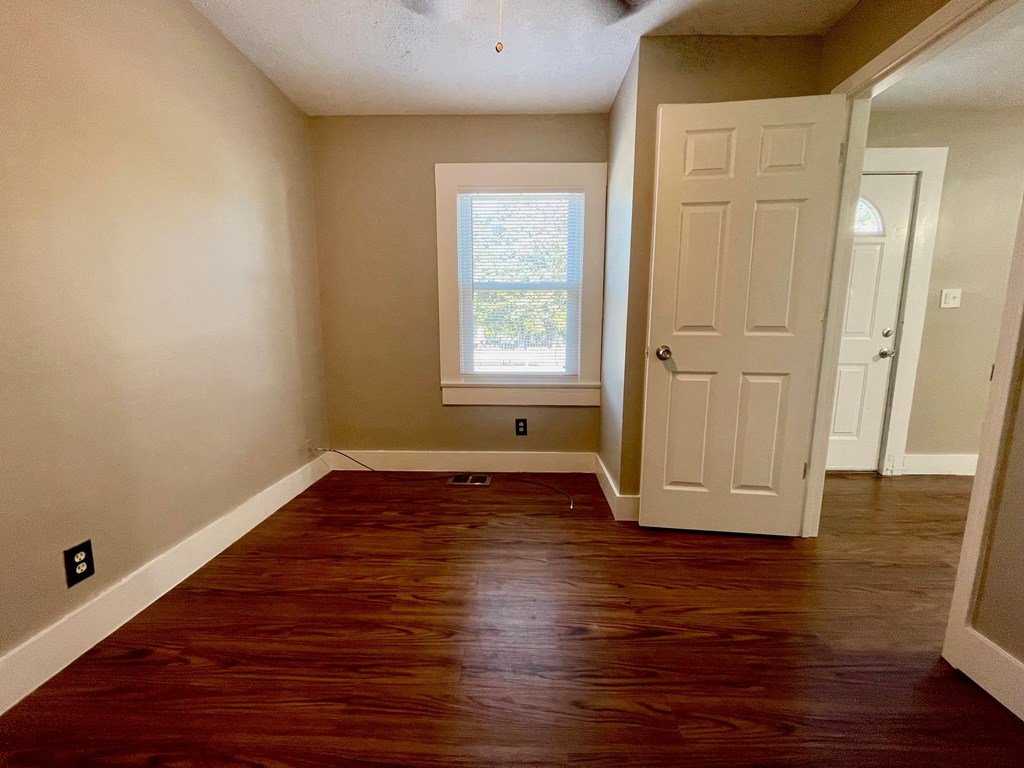 A room with a wooden floor and a white door.