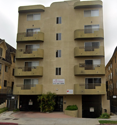 Apartment building with a sign that says "For Rent".