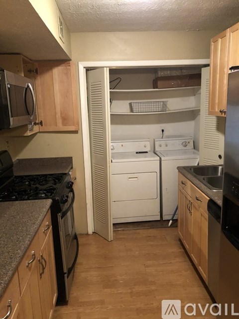 A kitchen with a black stove top oven and a white dishwasher.