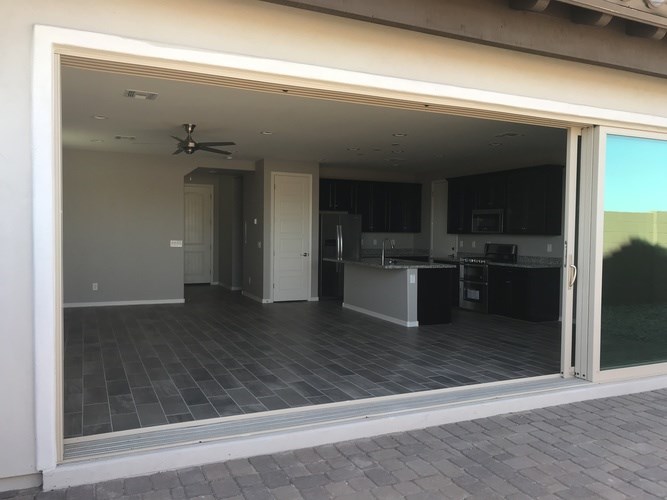 A modern house with a glass door leading to a kitchen.