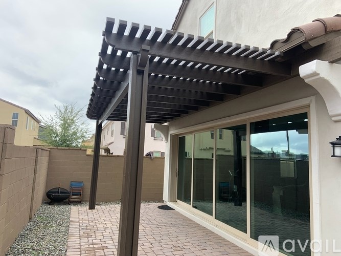 A patio with a glass door and a pergola.