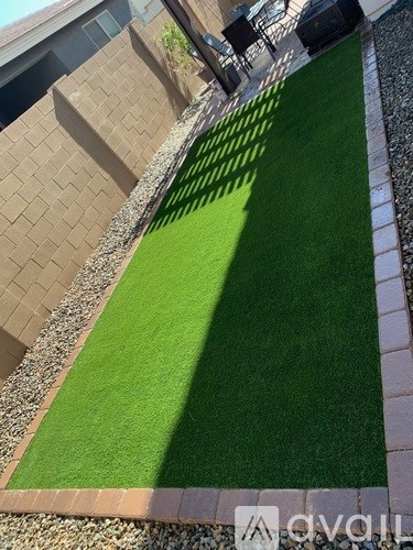 A green artificial grass lawn in a backyard.