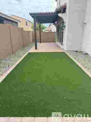 A row of palm trees in front of a building with a red roof.