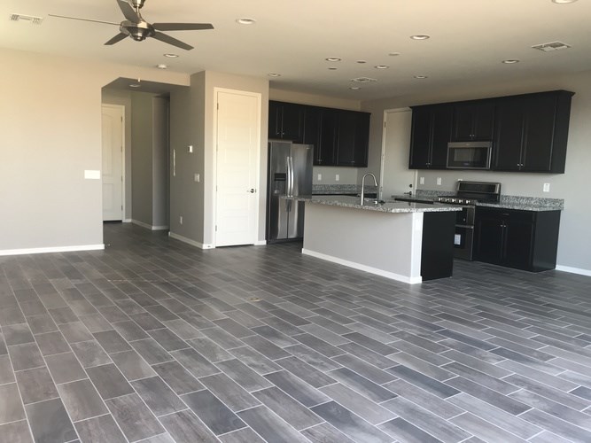 A kitchen with black cabinets and a fan on the ceiling.