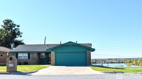 A house with a green garage door is for sale.
