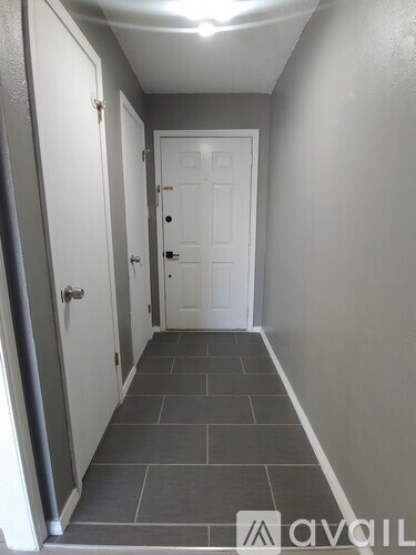 A hallway with a white door and a grey floor.