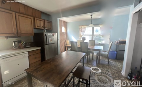 A kitchen with a table and chairs in front of a window.
