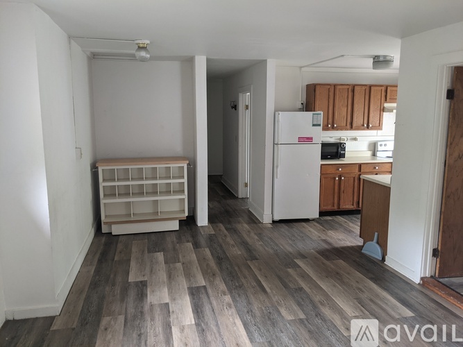 A kitchen with a white fridge and wooden cabinets.