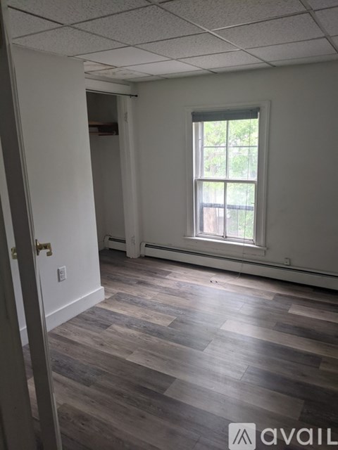 A room with a window and wooden flooring.