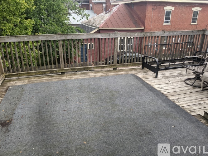 A patio with a black mat and a wooden deck.