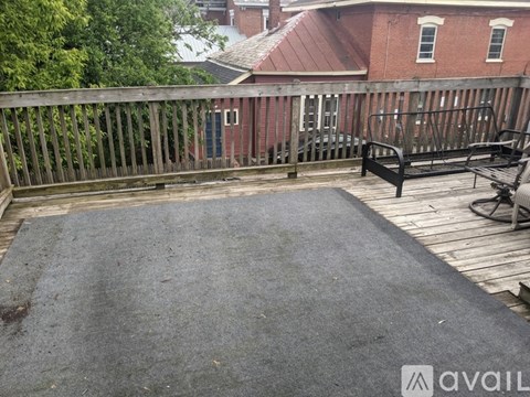 A patio with a black mat and a wooden deck.