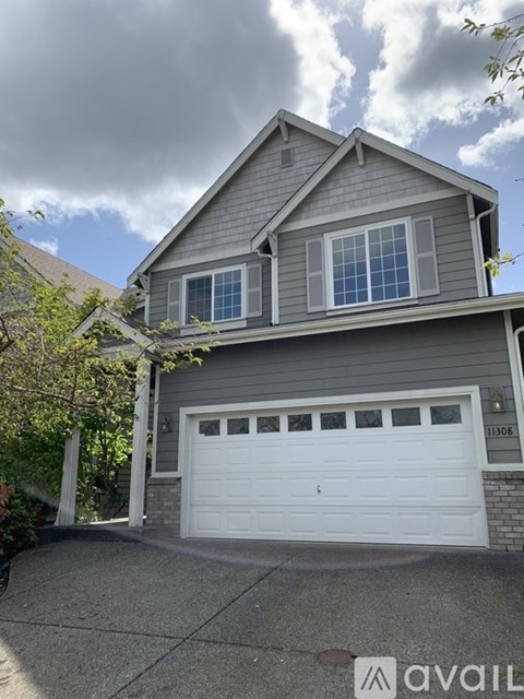 A two-story house with a garage and a driveway.