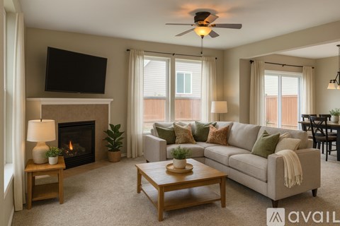 A living room with a fireplace and a ceiling fan.