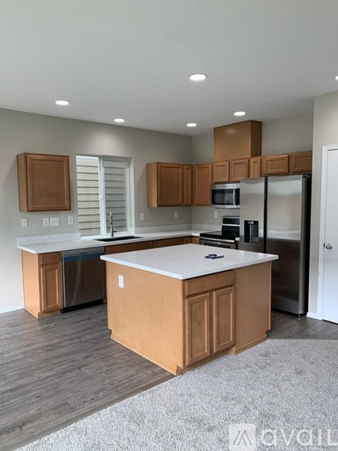 A kitchen with wooden cabinets and a white island.