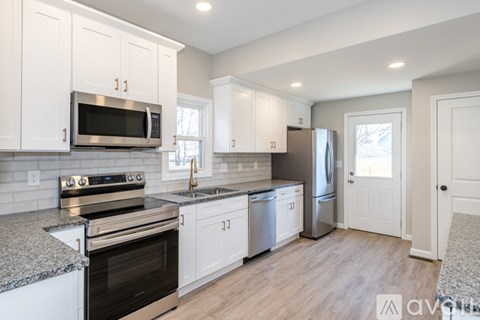 A kitchen with white cabinets and stainless steel appliances.