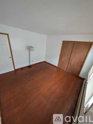 A room with wooden flooring and a white wall.