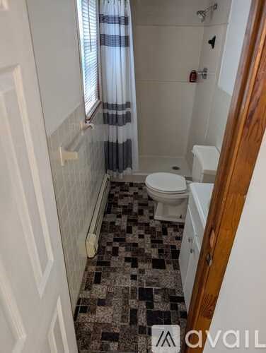 A bathroom with a toilet, sink, and tiled floor.