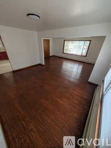 A room with wooden flooring and a window.