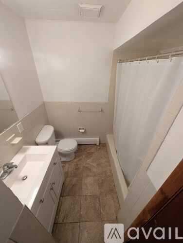 A bathroom with a toilet, sink, and shower.