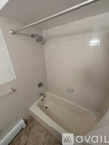 A bathroom with a tub and a shower head.