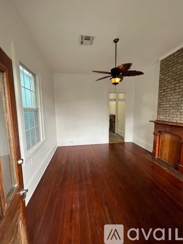 A room with a ceiling fan and wooden floors.