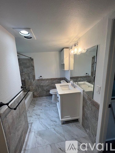 A bathroom with a marble floor and a white sink.