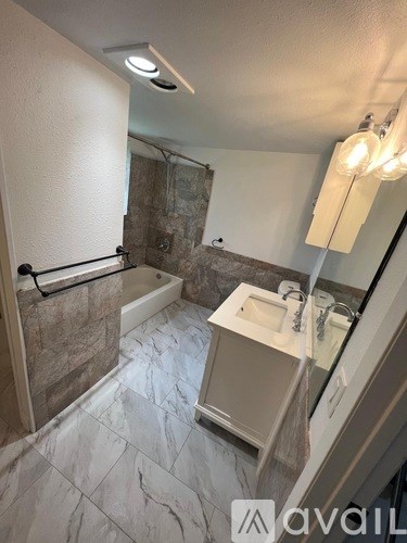 A bathroom with a marble tile floor and a walk-in shower.