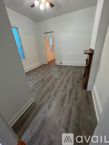 A room with wooden flooring and a window.