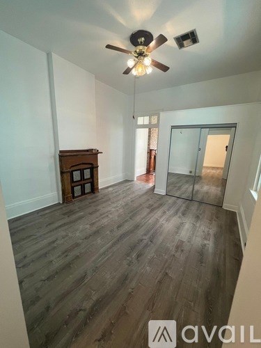 A room with wooden flooring and a ceiling fan.