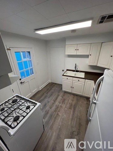 A small kitchen with a white stove and a window.