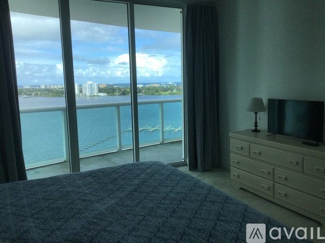 A bedroom with a large bed and a view of the water.