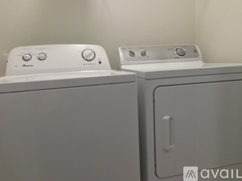 Two white front loading washing machines are side by side.