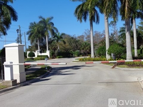 A gated entrance with a white gate and a red and white striped barrier.