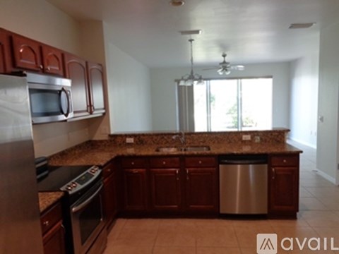 A kitchen with brown cabinets and granite countertops.