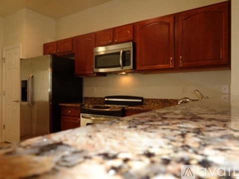 A kitchen with wooden cabinets and a granite countertop.