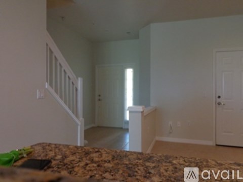 A room with a granite counter top and white walls.