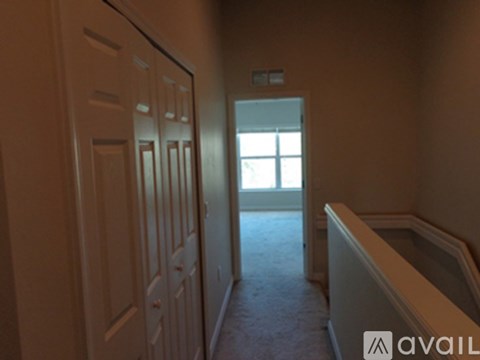 A hallway with a door on the left and a window on the right.