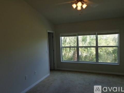 A room with a window and a ceiling fan.