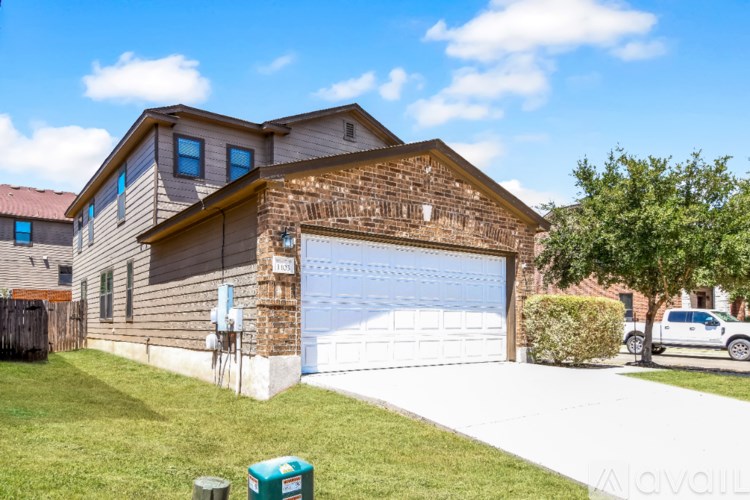 A house with a garage and a tree in front.